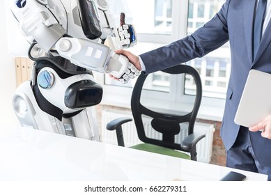 Businessman is standing in office with android - Powered by Shutterstock