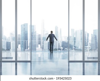 Businessman standing on a balcony and looking at city