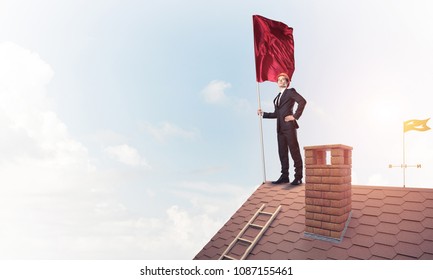 Businessman standing on house roof and holding red flag. Mixed media - Shutterstock ID 1087155461