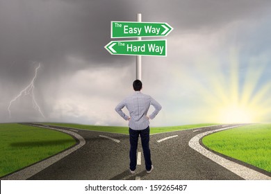 Businessman Is Standing On The Road With Sign Of Easy Vs Hard Way