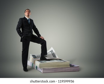 Businessman standing on a stack of dollars