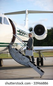 Businessman Standing On Stairs To Private Jet