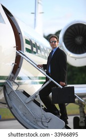 Businessman Standing On Stairs To Private Jet