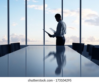 businessman standing with paper in office