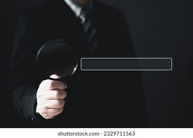 Businessman standing in suit holding magnifying glass.Searching Browsing Internet Data Information with blank search bar. Search Engine Optimization SEO Networking Concept.
