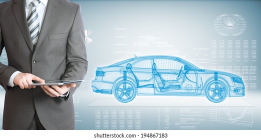 Businessman standing with tablet pc . On background of the high-tech wire frame car and graphs - Powered by Shutterstock