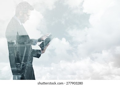 Businessman standing while using a tablet pc against new york skyline