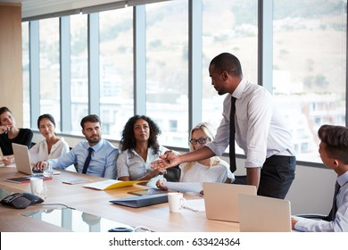 Businessman Stands To Address Meeting Around Board Table - Shutterstock ID 633424364
