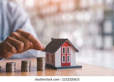 Businessman Steps Coins To Find A Model House. Collecting Money To Buy A House Financial Service Concept And Saving