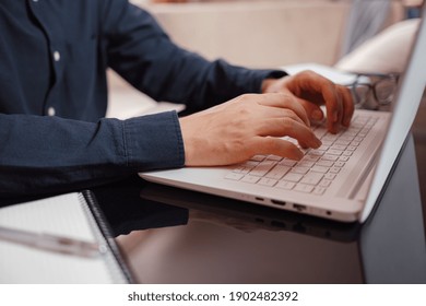 Businessman or student using laptop at home, Man hands typing on computer keyboard closeup, online learning, internet marketing, working from home, office workplace freelance concept