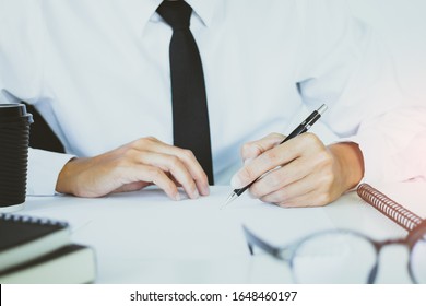 Businessman In A Suit And Black Tie Using A Pen Writing On Paper For The Document.Sign Signature Legally Binding Law