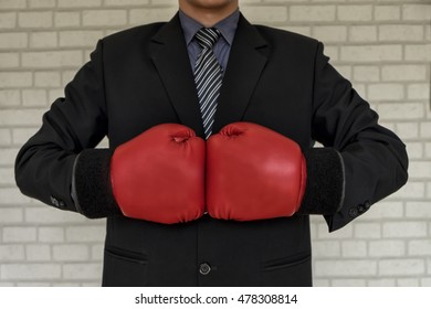 Businessman in suit with with boxing gloves, tough competitive business concept, business concept, vintage tone, soft focus - Powered by Shutterstock