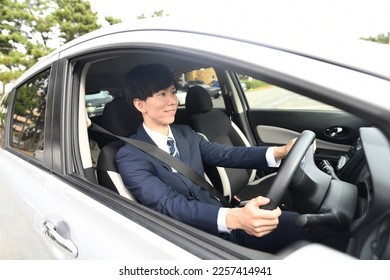 A businessman in a suit driving a car