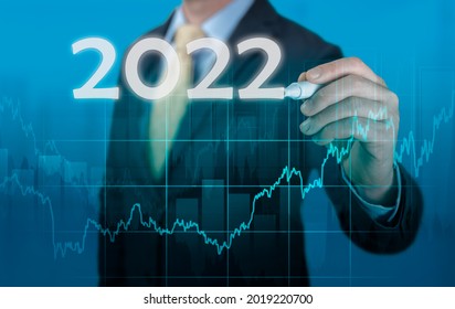 Businessman In Suit Forecast Analysis Plan Profit Chart. Economic Forecasts For 2022. Businessman Writes 2022 On Virtual Screen. Economic Recovery After Fall Due To Covid 19 Coronavirus Pandemic