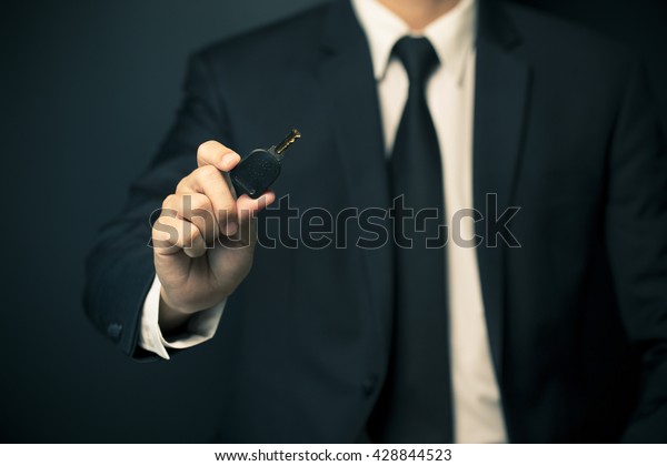 Businessman in suit giving a\
key