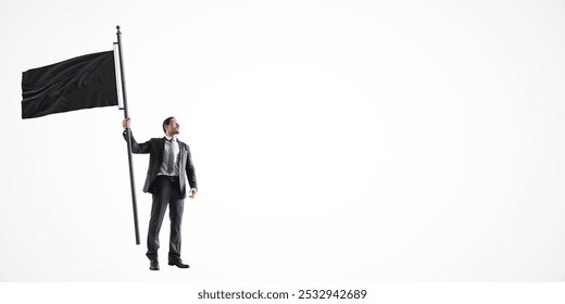 A businessman in a suit holding a large black flag, standing on a clean white background. The image represents leadership, success, or protest - Powered by Shutterstock