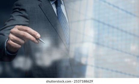 Businessman in a suit holding a pen, writing on a virtual screen. Professional attire, corporate setting, and business focus. Office environment, business theme. Businessman photo. - Powered by Shutterstock