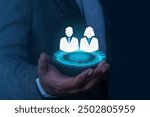 Businessman in suit holding person icon on virtual screen. Personnel recruitment concept, job placement, strategic planning for personnel management and teamwork for success. 
