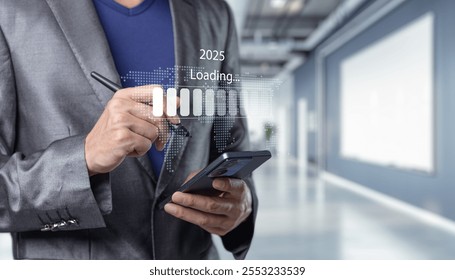 A businessman in a suit interacts with a smartphone, showing a digital loading screen for the year 2025, symbolizing future growth and innovation in a modern office environment. - Powered by Shutterstock