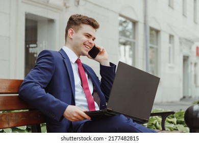 Businessman In Suit With Laptop Speak On Phone Sitting On Bench. Cold Calling, Sales Manager