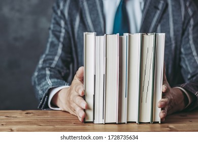 Businessman In A Suit With Multiple Books