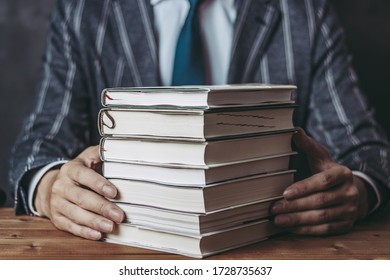 Businessman In A Suit With Multiple Books