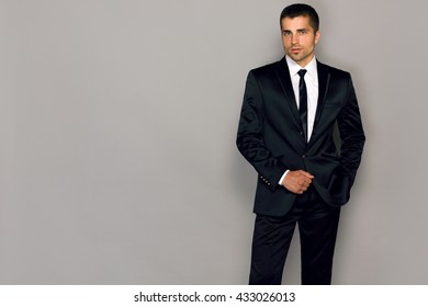 Businessman In A Suit On A Gray Background Young Male Model In A Black Suit And Tie