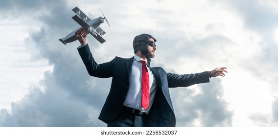businessman in suit and pilot hat launch plane toy. flight - Shutterstock ID 2258532037