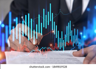 Businessman in suit signs contract. Double exposure with forex graph hologram. Man signing brokerage agreement. Financial market analysis and investment concept. - Powered by Shutterstock