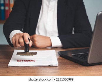 Businessman in a suit stamped for canceled documents while sitting at the table in the office. Business and document management concept - Shutterstock ID 2251380999