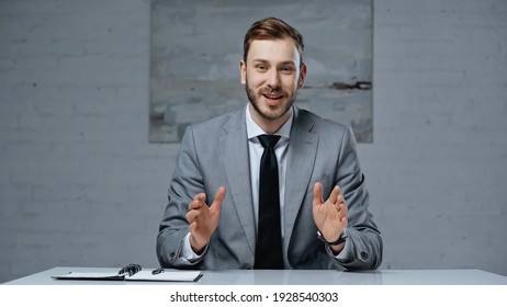 Businessman In Suit Talking While Gesturing During Interview In Office