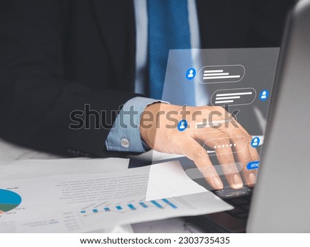 Businessman in a suit typing on a keyboard laptop with live chat chatting on application communication digital media websites and social network. Concept of technology and communication