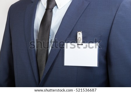 Businessman in suit wearing a blank ID tag or name card during an exhibition or a conference