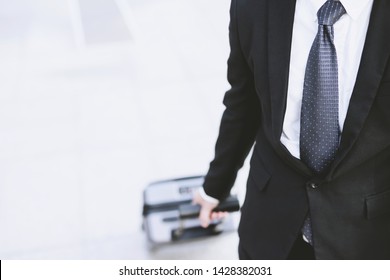 businessman in suits walking outside public transport building with luggage in rush hour. Business traveler pulling suitcase in modern airport terminal. baggage business Trip.  Copy space , top view