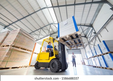 Businessman supervising forklift truck driver worker in solar panel factory warehouse - Powered by Shutterstock