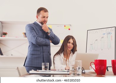 Businessman supervising his assistant's work on the laptop computer. Man helps woman in the office. Male boss and female secretary. Communication of manager and staff, checking job execution - Shutterstock ID 465181010