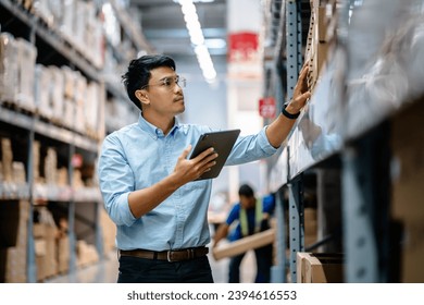 Businessman or supervisor uses a digital tablet to check the stock inventory on shelves in large warehouses, a Smart warehouse management system, supply chain and logistic network technology concept. - Powered by Shutterstock