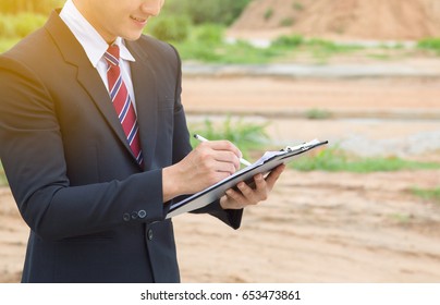 Businessman Surveying Land For Industrial Project.Selective Focus At Hand.