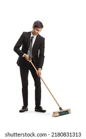 Businessman sweeping with a broom isolated on white background