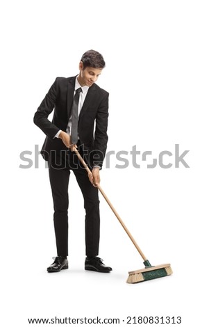 Businessman sweeping with a broom isolated on white background