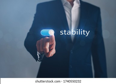 Businessman switch on  Stability button. Stability business concept.