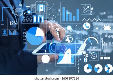 Businessman with tablet computer using virtual screen on grey background. Concept of modern business technologies