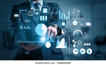 Businessman with tablet computer using virtual screen on dark background. Concept of business planning