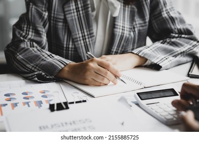 Businessman takes notes in a notebook, owns a startup company, sits in his office and checks the company's financial summary prepared by the finance department. Management concept of startup company.