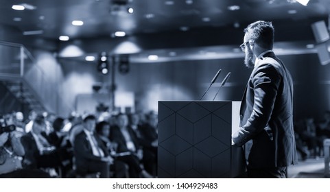 Businessman takes a picture of corporate business presentation at conference hall using smartphone. Business and Entrepreneurship concept. Focus on unrecognizable person in audience. - Shutterstock ID 1404929483