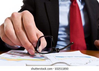 Businessman taking his eyeglasses from the desk - Shutterstock ID 102511850