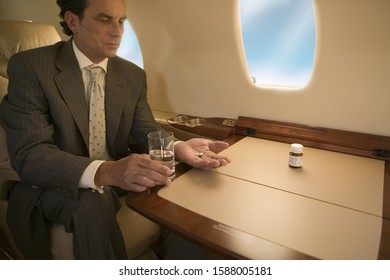 Businessman Taking Medication On Airplane Stock Photo 1588005181   Businessman Taking Medication On Airplane 260nw 1588005181 