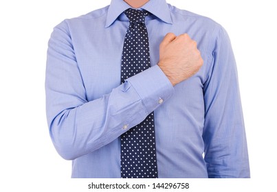 Businessman taking oath with fist over heart.