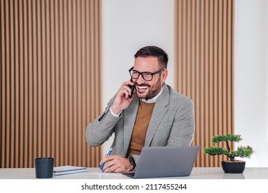 Businessman Taking A Phone Call At Work Happy Young Adult Businessman Smiling While Speaking On His Cellphone In A Modern Office Confident Businessman Using Smartphone Closing Business Deals At Work