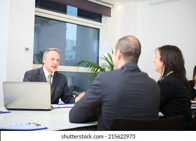 Businessman talking to a couple in a office